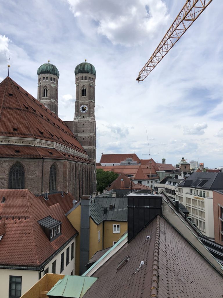 Bild von den Dächern in München mit einer Kirche im Hintergrund.